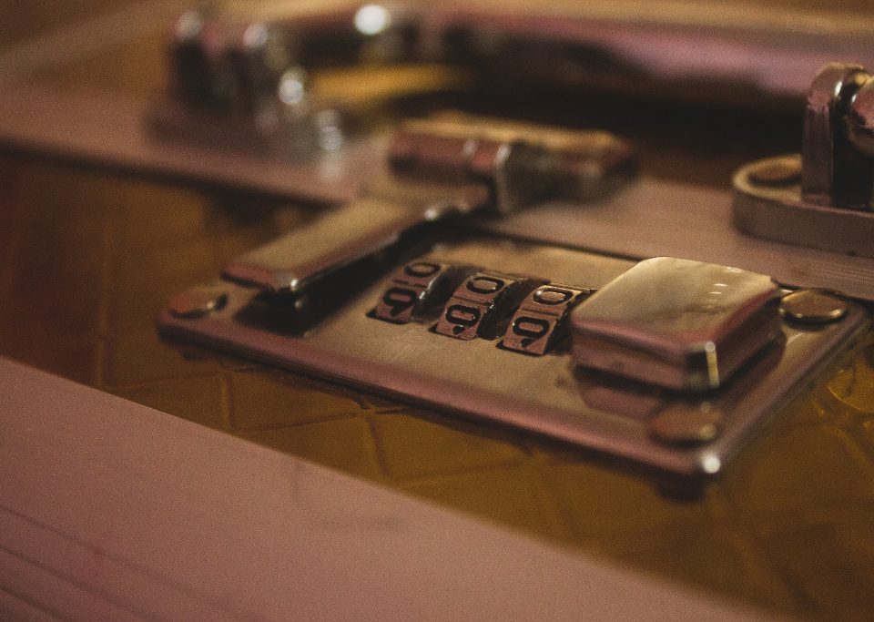 Close up of luggage combination lock that is latched closed.