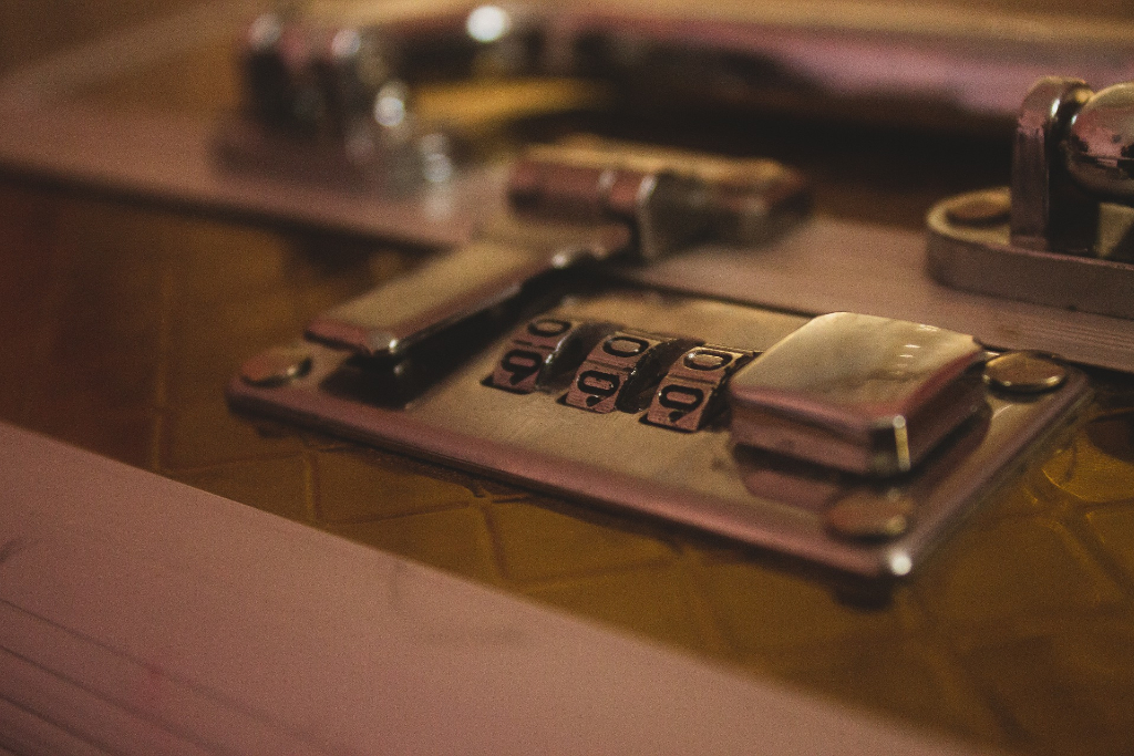 Close up of luggage combination lock that is latched closed.