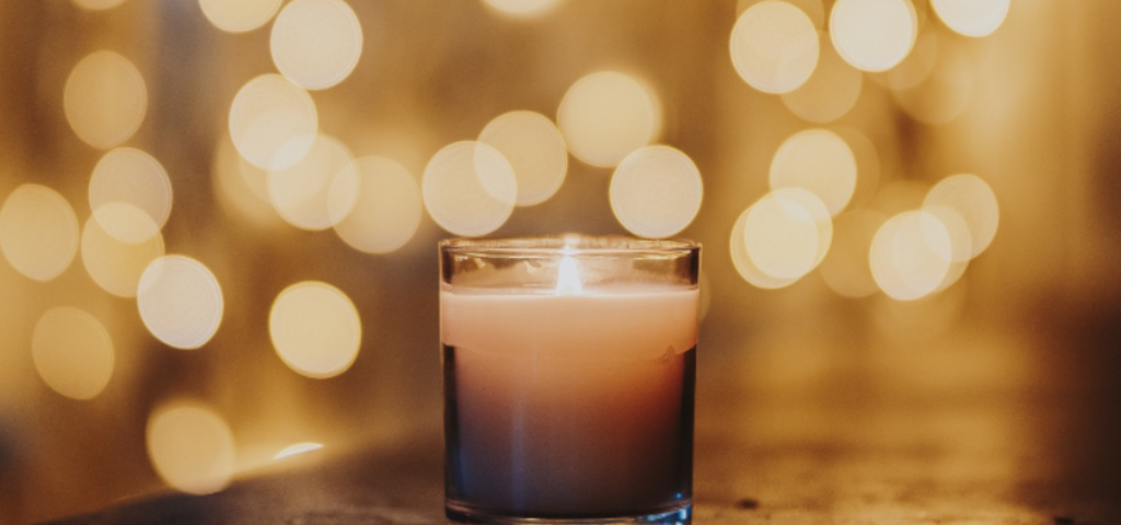 A little candle in the foreground, a net of light blurred in the background.