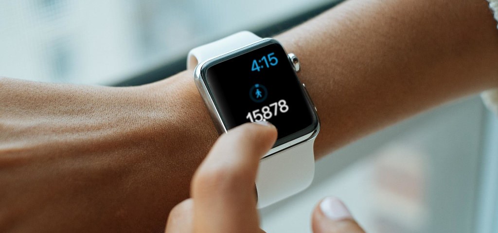 Bridge the Gap decorative image of woman checking smart watch with nearly 16,000 steps on it.