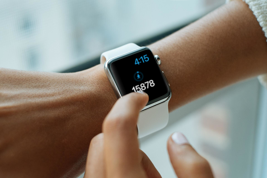 Bridge the Gap decorative image of woman checking smart watch with nearly 16,000 steps on it.