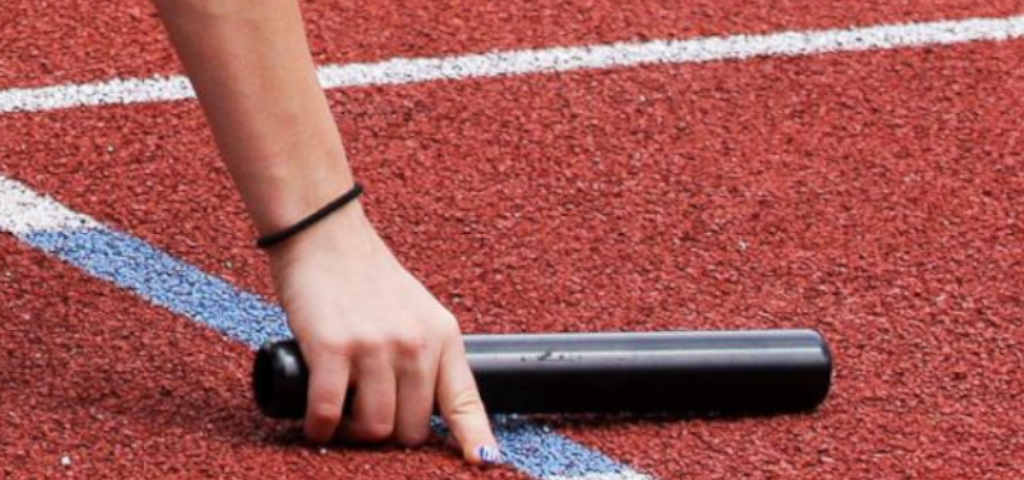 Pass the baton image is decorative, a female hand reaches down to pull a track and field baton off of the track