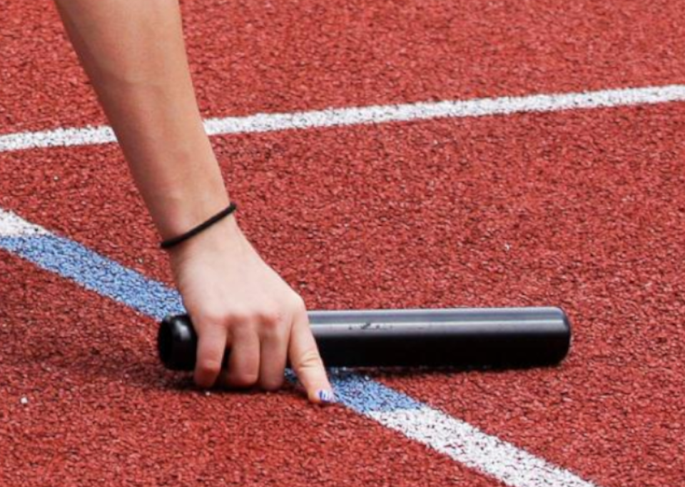 Pass the baton image is decorative, a female hand reaches down to pull a track and field baton off of the track